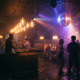 Belebte Bar mit Dancefloor, Edison-Glühbirnen und Diskokugel tauchen Menschenmenge in Bernstein- und Violetttöne.