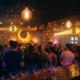 Belebte Münchner Bar mit tanzender Menge, Edison-Glühbirnen und Diskokugeln, die goldenes Licht auf Backsteinwände werfen.