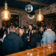 Münchner Bar mit Discokugel, Vintage-Glühbirnen und tanzenden Gästen auf einem stimmungsvollen Dancefloor mit Backsteinwänden.