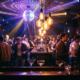 Drehende Discokugel verstreut Licht über tanzende Menge in Münchner Bar mit Edison-Glühbirnen und violetten Akzenten.