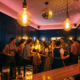 Belebte Oktoberfest-Party in einer Bar mit Edison-Glühbirnen, Diskokugel und Cocktailgläsern in warmem Goldlicht.